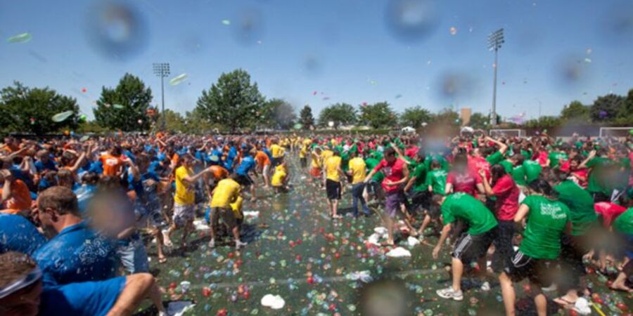 In an open area, participants are having fun fighting with water balloons.