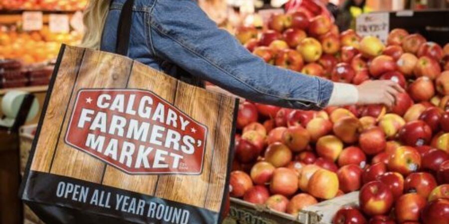 Calgary`s farmer market, a woman buying fresh apples. A fun activities to do.